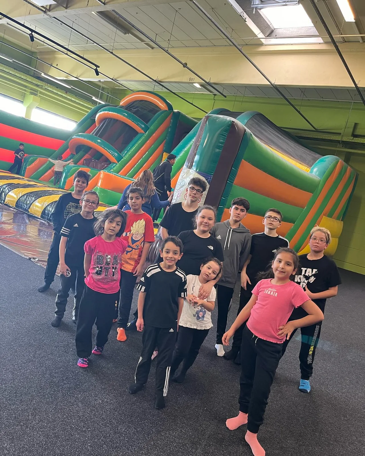 Kinder und Erwachsene von Black Tiger stehen gemeinsam in einer Indoor-Spielhalle