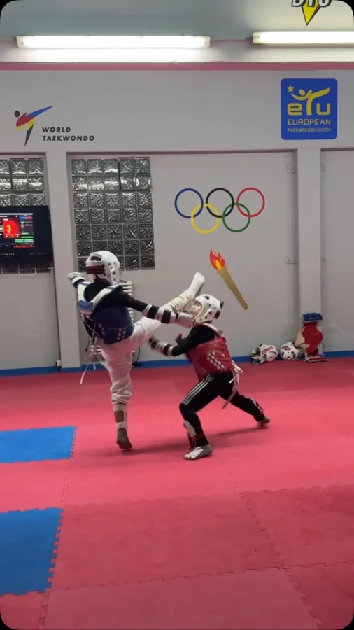 Zwei Kinder üben Sparring mit Helm und rotem beziehungsweise blauem Körperschutz.
