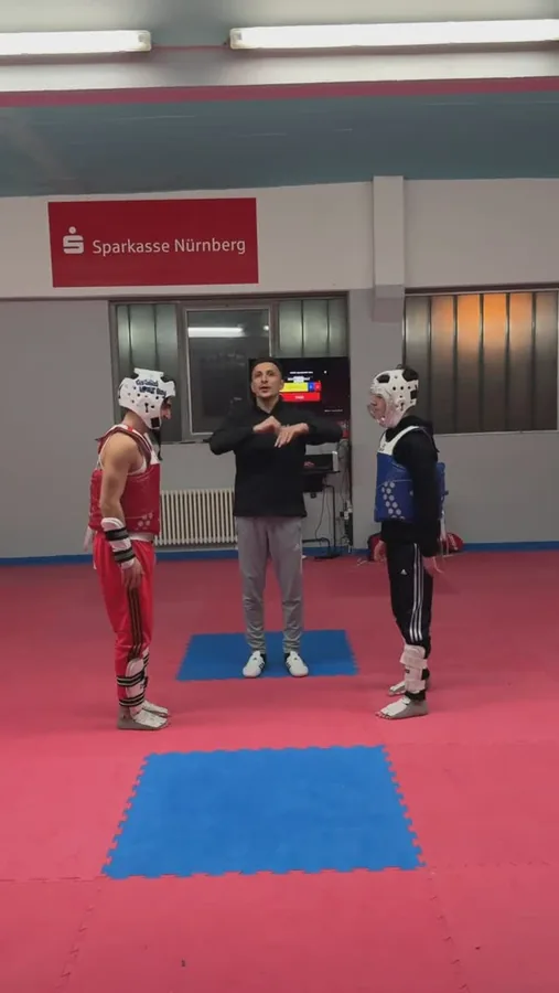 Ein Trainer erklärt zwei Kindern mit Schutzhelm und Körperschutz eine Übung.
