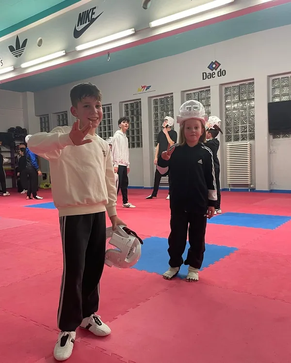 Zwei Kinder stehen während einer Trainingspause zusammen auf der Matte.